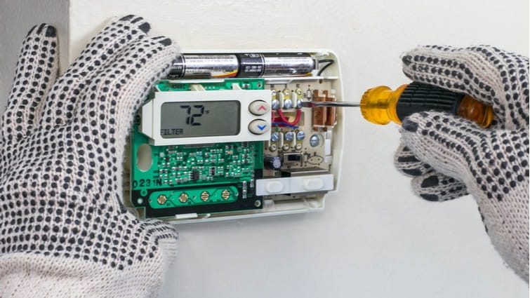 Persona con guantes cambiando un termostato